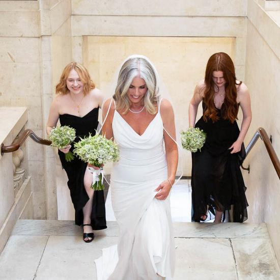  Bride walking up the Town Hall stairs with 2 bridesmaids